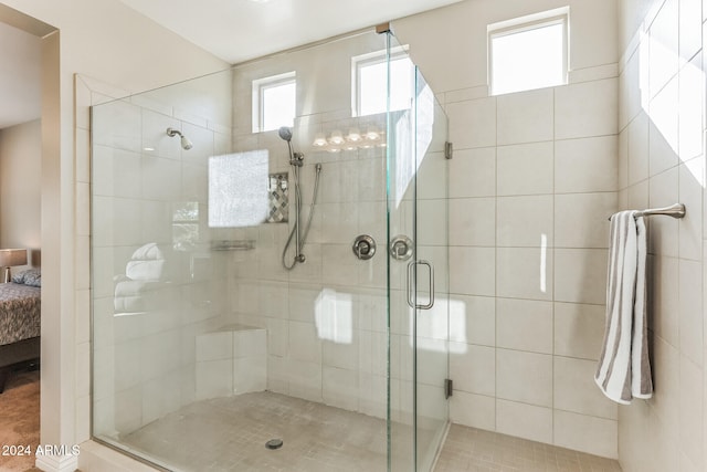 bathroom featuring a shower with door and a healthy amount of sunlight