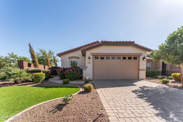 mediterranean / spanish-style house featuring a garage and a front lawn