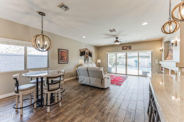 interior space with dark hardwood / wood-style floors and ceiling fan with notable chandelier