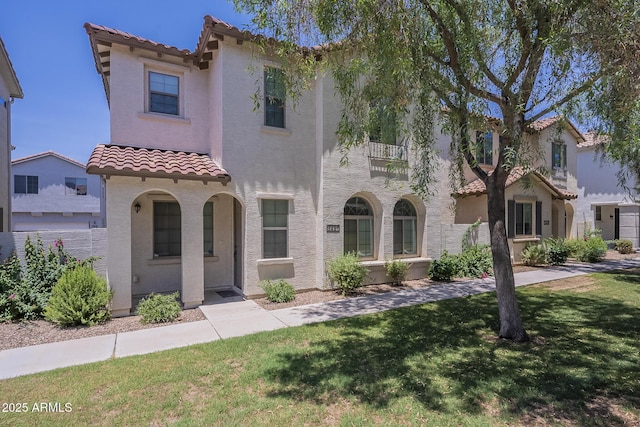 3451 S Wren Dr, Gilbert, AZ 85297 - mediterranean / spanish house featuring a tile roof, stucco siding, a front yard, and a balcony