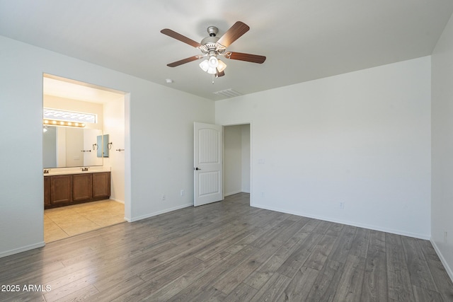 3451 S Wren Dr, Gilbert, AZ 85297 - unfurnished bedroom featuring wood finished floors, connected bathroom, and a ceiling fan