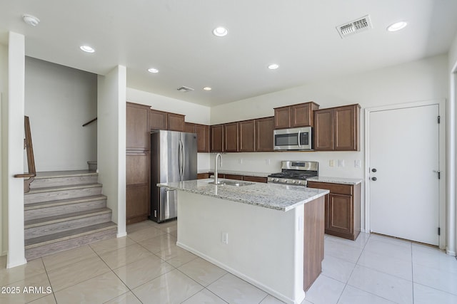3451 S Wren Dr, Gilbert, AZ 85297 - kitchen with appliances with stainless steel finishes, a center island with sink, light stone counters, recessed lighting, and light tile patterned flooring