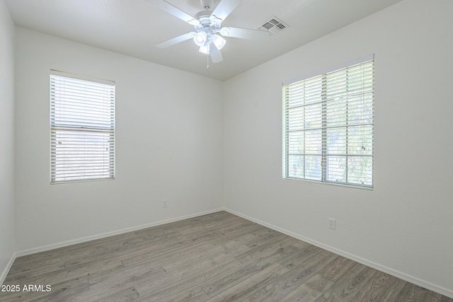 3451 S Wren Dr, Gilbert, AZ 85297 - empty room with light wood finished floors, healthy amount of natural light, and a ceiling fan