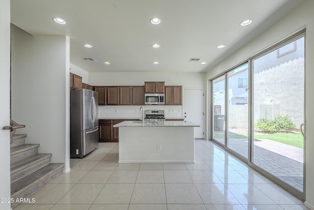 3451 S Wren Dr, Gilbert, AZ 85297 - kitchen featuring stainless steel appliances, recessed lighting, light stone countertops, a kitchen island with sink, and light tile patterned floors