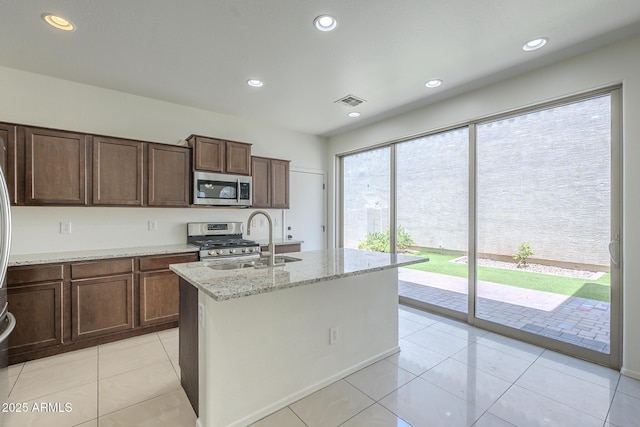 3451 S Wren Dr, Gilbert, AZ 85297 - kitchen with appliances with stainless steel finishes, light stone countertops, an island with sink, recessed lighting, and light tile patterned flooring