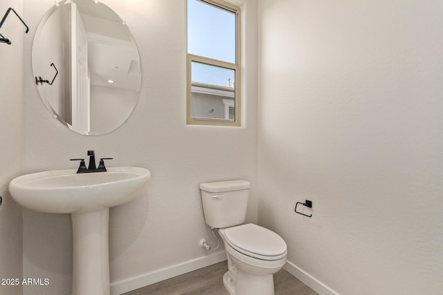 bathroom featuring wood-type flooring and toilet