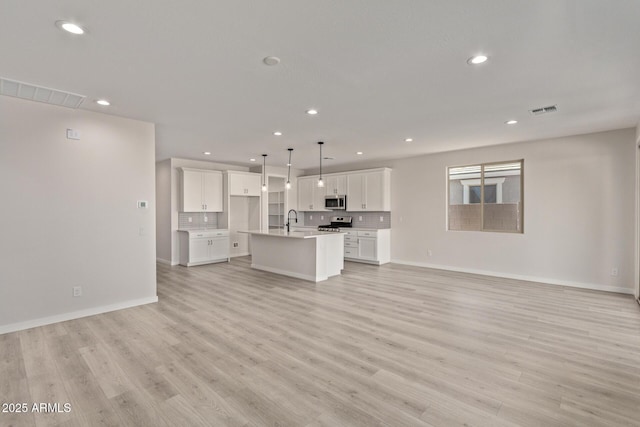 unfurnished living room with light wood-type flooring and sink