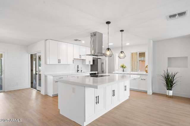 11220 N 109th Ave, Sun City, AZ 85351 - kitchen featuring island range hood, light countertops, light wood finished floors, recessed lighting, and freestanding refrigerator