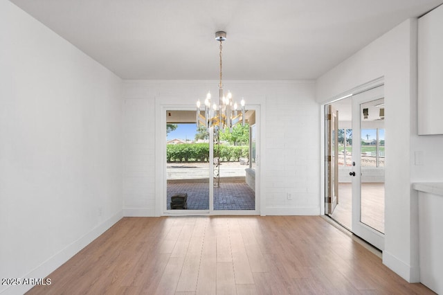 11220 N 109th Ave, Sun City, AZ 85351 - unfurnished room with a chandelier, healthy amount of natural light, and wood finished floors
