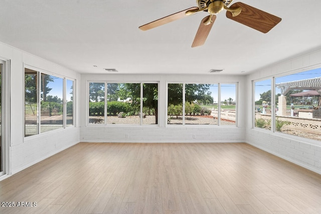 11220 N 109th Ave, Sun City, AZ 85351 - unfurnished sunroom featuring brick wall, a ceiling fan, plenty of natural light, and wood finished floors