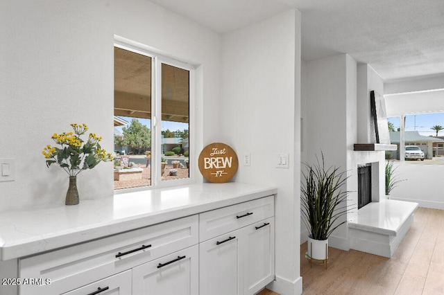 11220 N 109th Ave, Sun City, AZ 85351 - detailed view of wood finished floors, a fireplace with raised hearth, and baseboards