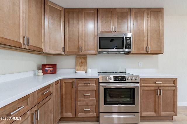 1210 W La Jolla Dr, Tempe, AZ 85282 - kitchen with appliances with stainless steel finishes, light countertops, and brown cabinets