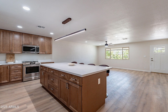 1210 W La Jolla Dr, Tempe, AZ 85282 - kitchen featuring stainless steel appliances, a ceiling fan, light wood finished floors, recessed lighting, and light countertops