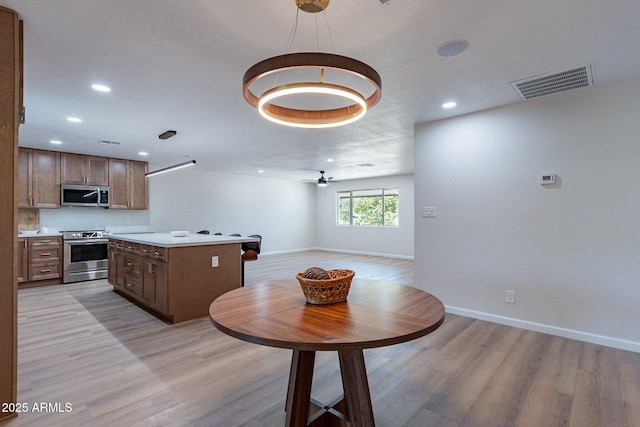 1210 W La Jolla Dr, Tempe, AZ 85282 - kitchen with appliances with stainless steel finishes, light wood-style flooring, recessed lighting, light countertops, and open floor plan