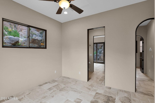 4393 N Twisted Trl, Prescott, AZ 86301 - spare room with arched walkways, a ceiling fan, and stone tile floors