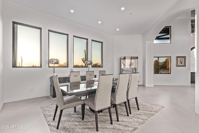 dining room featuring recessed lighting, arched walkways, and light tile patterned flooring