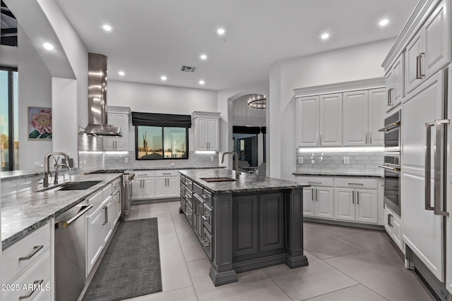 kitchen featuring a sink, stainless steel appliances, visible vents, and island exhaust hood