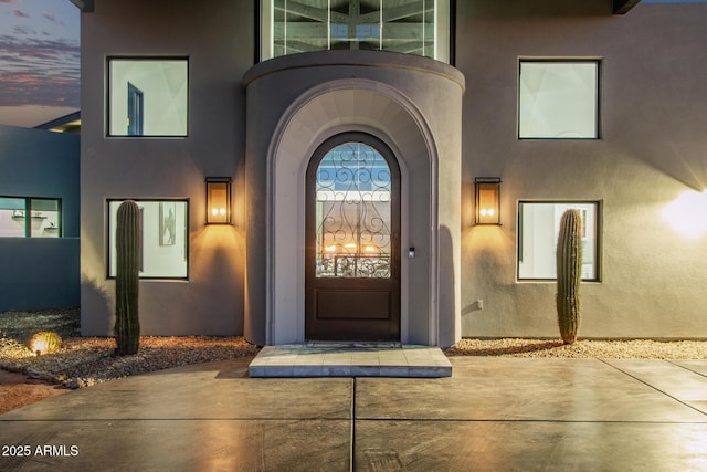 doorway to property featuring stucco siding