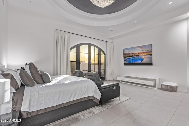 bedroom featuring a tray ceiling, recessed lighting, french doors, and arched walkways