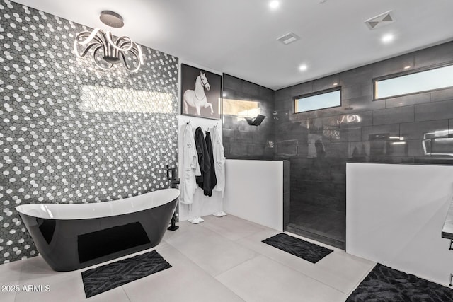 full bath with visible vents, a freestanding tub, a walk in shower, and tile patterned flooring