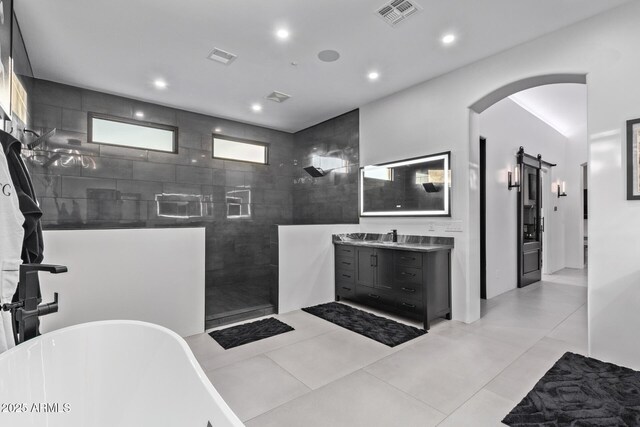 bathroom featuring visible vents, a walk in shower, tile patterned flooring, a freestanding bath, and vanity