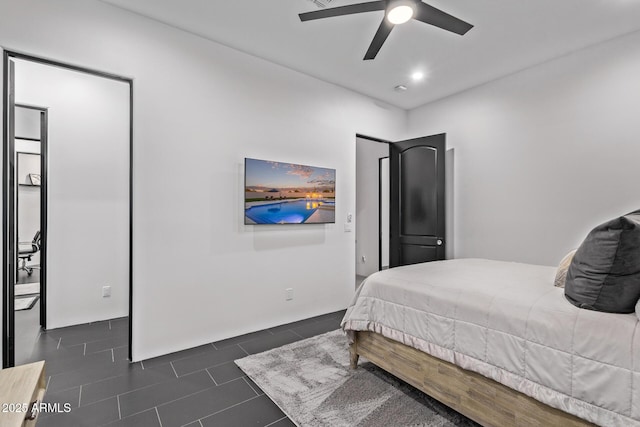 bedroom with dark tile patterned floors and ceiling fan