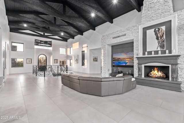 tiled living room with beamed ceiling, high vaulted ceiling, wooden ceiling, and a fireplace