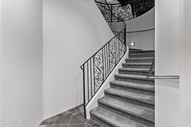 stairway featuring stone tile floors