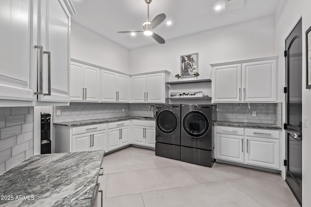 washroom featuring washer and dryer, a sink, cabinet space, light tile patterned floors, and ceiling fan