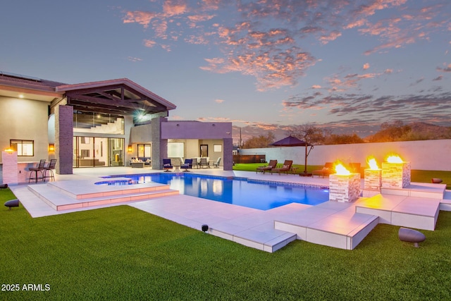 pool at dusk with a fenced in pool, a patio, and a lawn