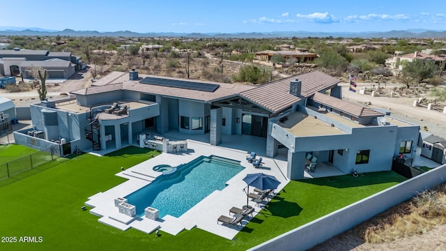 exterior space featuring a lawn, solar panels, a fenced backyard, and a patio area