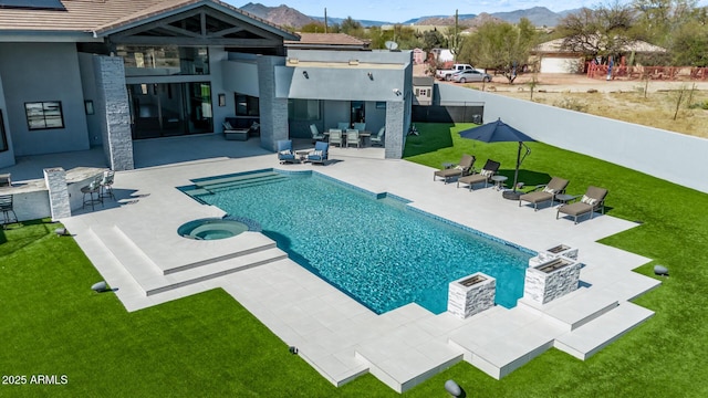 view of pool featuring a patio area, a mountain view, and a yard