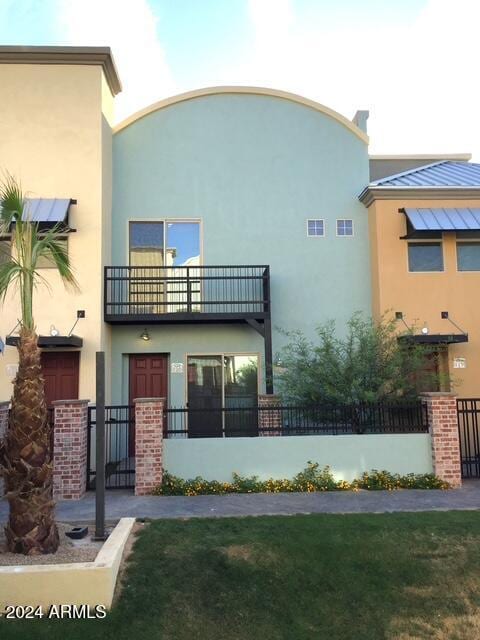 rear view of property with a yard and a balcony