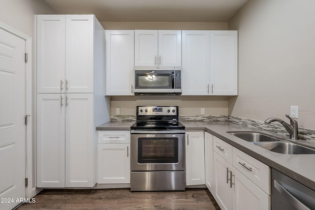 kitchen featuring white cabinets, sink, stainless steel appliances, and dark wood-type flooring