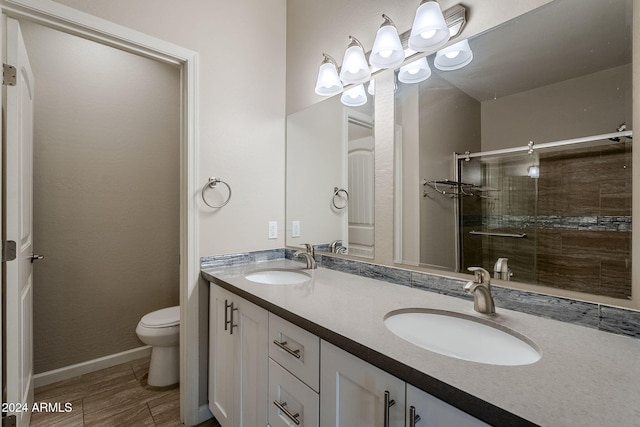 bathroom featuring vanity, toilet, and an enclosed shower