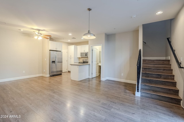 unfurnished living room with light hardwood / wood-style flooring and ceiling fan