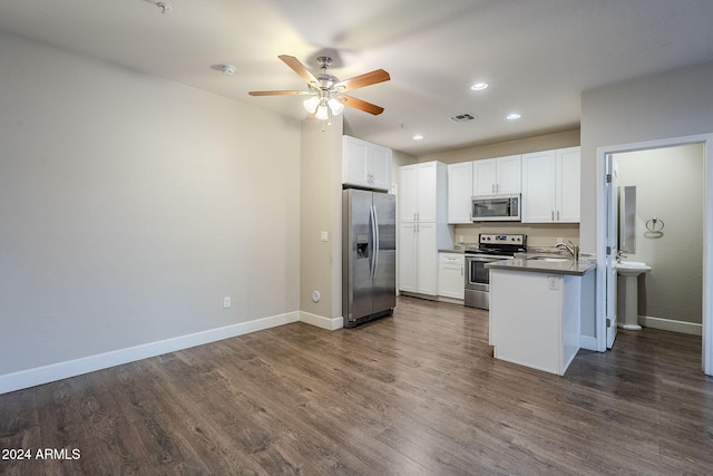 kitchen with kitchen peninsula, white cabinets, stainless steel appliances, and dark hardwood / wood-style floors