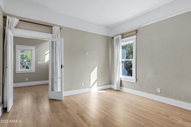 empty room with french doors, baseboards, and wood finished floors