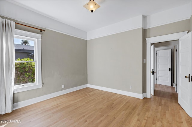 spare room featuring light wood-style flooring and baseboards