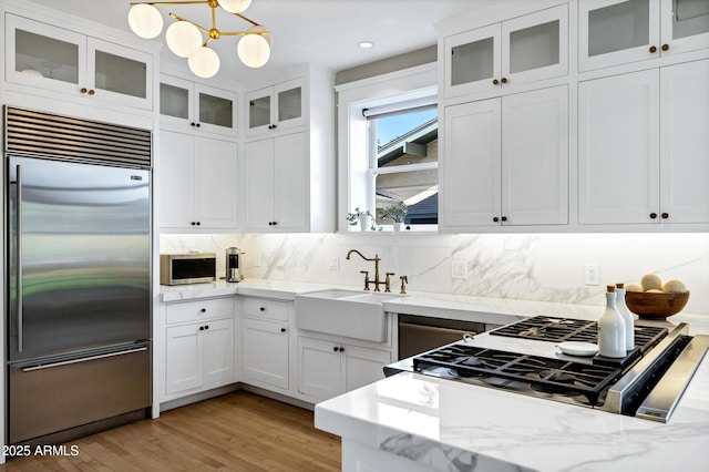 kitchen featuring appliances with stainless steel finishes, a sink, and white cabinets