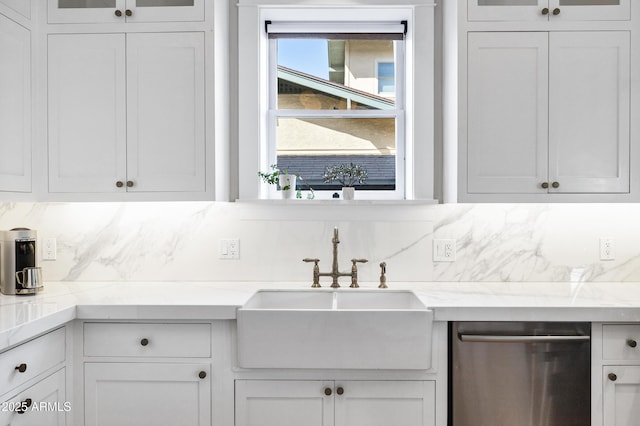 kitchen featuring dishwasher, a sink, white cabinets, and decorative backsplash