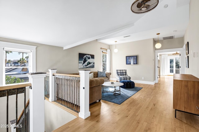 living room featuring a wealth of natural light, light wood-type flooring, and visible vents