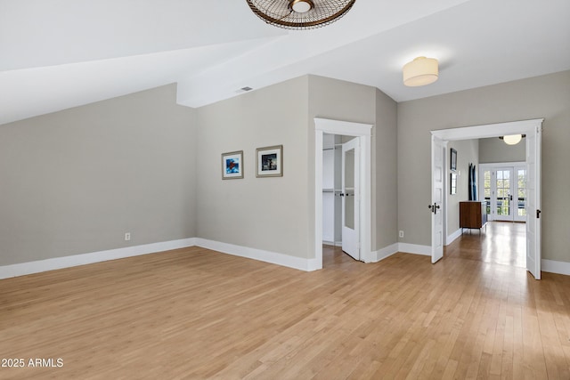 interior space with visible vents, baseboards, vaulted ceiling, light wood-style floors, and french doors