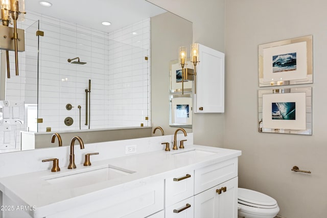 bathroom featuring double vanity, a tile shower, and a sink