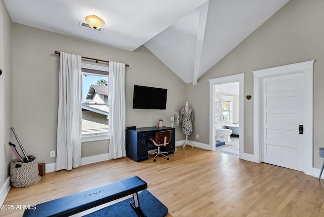 interior space with lofted ceiling, wood finished floors, visible vents, and baseboards