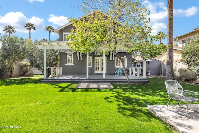 back of property featuring french doors, a lawn, fence, a deck, and a pergola