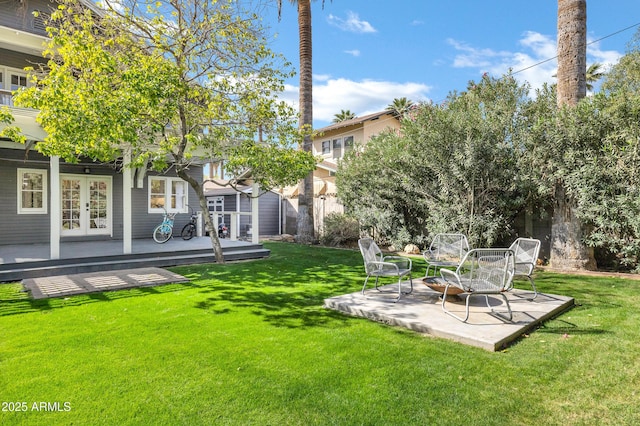 view of yard with a patio area, fence, a deck, and french doors