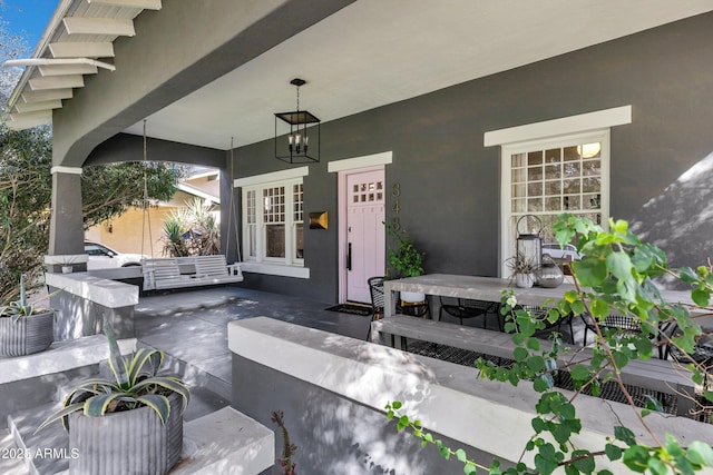 entrance to property with outdoor dining space, a patio area, and stucco siding