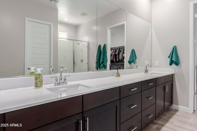 3852 E Bartlett Way, Chandler, AZ 85249 - bathroom with a stall shower, double vanity, wood finished floors, and a walk in closet