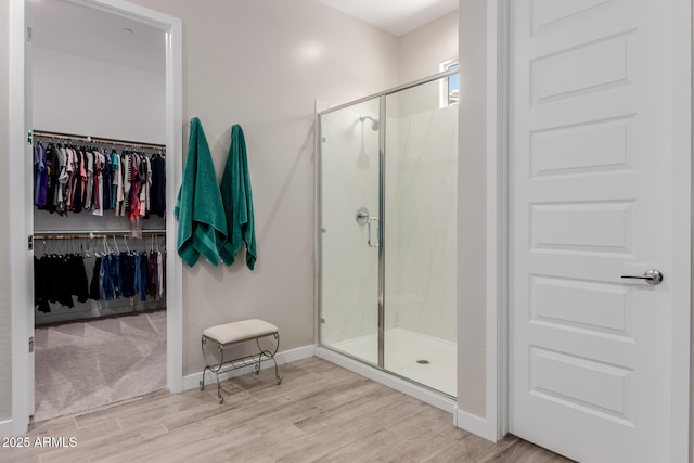 3852 E Bartlett Way, Chandler, AZ 85249 - full bath with wood finished floors, a stall shower, a walk in closet, and baseboards
